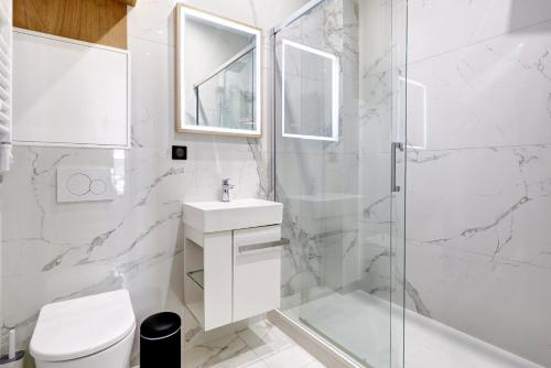 une salle de bain blanche avec un lavabo et une douche dans l'établissement Bluestay 288 - Superbe studio à Paris 17, à Paris