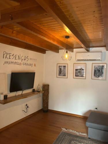 a living room with a flat screen tv on a wall at Casa da Cantarinha in Fundão