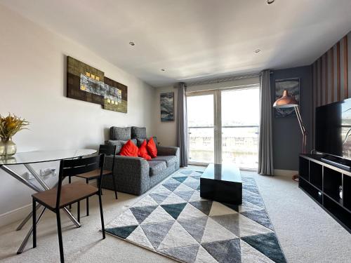 a living room with a couch and a table at Seaside APT with Harbour View in Swansea