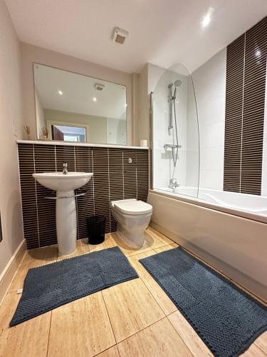 un bagno con lavandino, WC e vasca di Seaside APT with Harbour View a Swansea