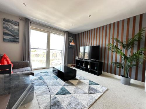 a living room with a couch and a tv at Seaside APT with Harbour View in Swansea