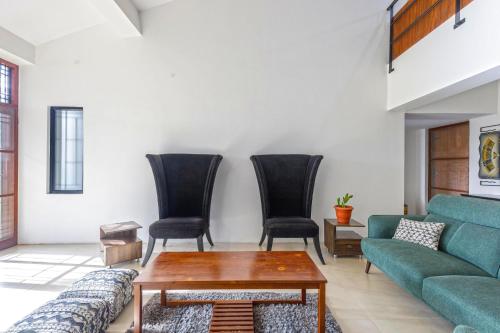 a living room with a couch and chairs at Grandeur Villa by StayJade Huge Garden 5BHK in Yelahanka