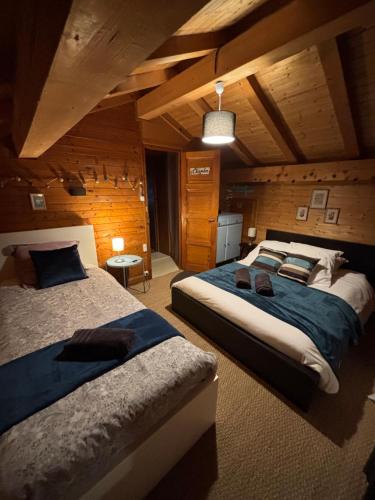 - une chambre avec 2 lits dans une pièce en bois dans l'établissement CHALET FAMILIAL AU PIED DES PISTES ET COMMERCES, à Cohennoz