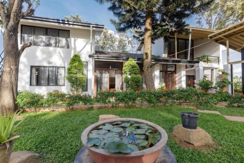 a house with a garden with a pond in the yard at Grandeur Villa by StayJade Huge Garden 5BHK in Yelahanka