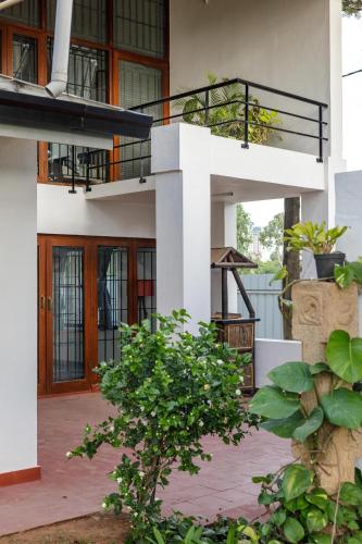 a white house with a staircase and a balcony at Grandeur Villa by StayJade Huge Garden 5BHK in Yelahanka