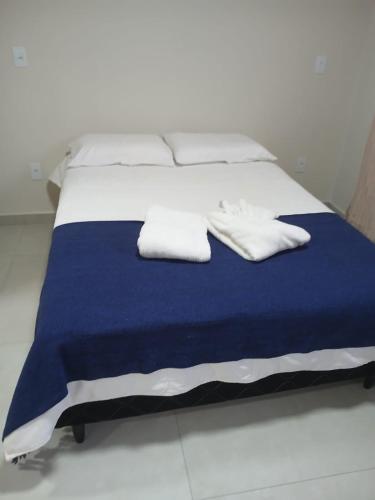 a bed with two white pillows and a blue blanket at Pousada da Elizângela de Amarantina in Ouro Preto