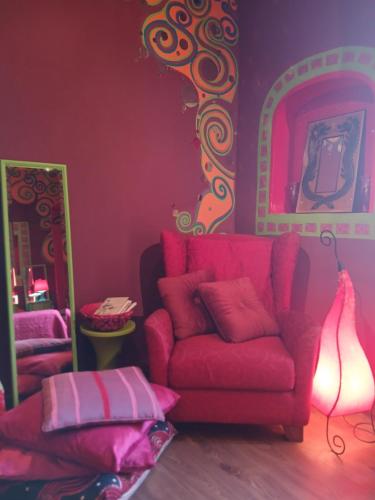 a living room with a red couch and a lamp at Suite d'Artista Calcata in Calcata