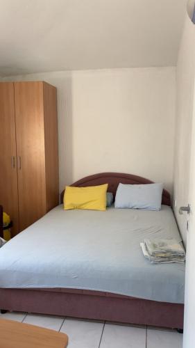 a bedroom with a bed with two yellow pillows at Apartman Drazen Rafailovici in Rafailovici