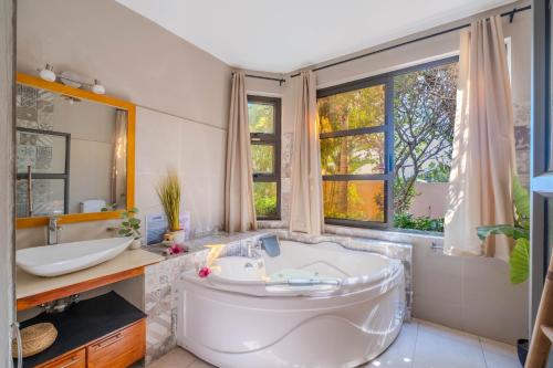 a bathroom with a large tub and a sink at Villa centre Grand Baie in Grand Baie