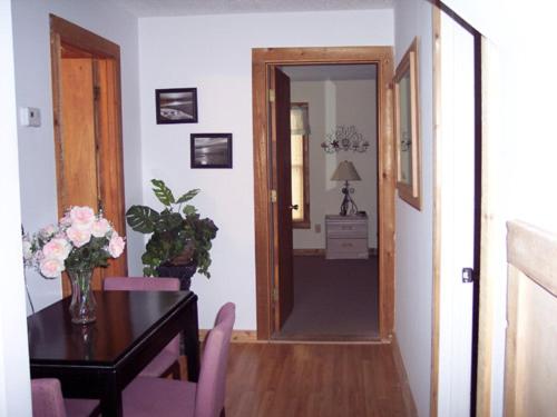 a dining room with a table and a door leading to a hallway at Atlantic Winds Condos in Myrtle Beach