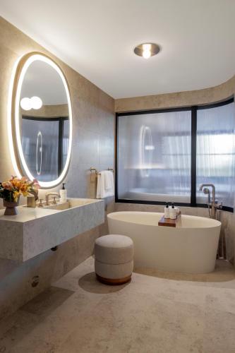 a bathroom with a tub and two sinks and a large window at The Moore Miami in Miami