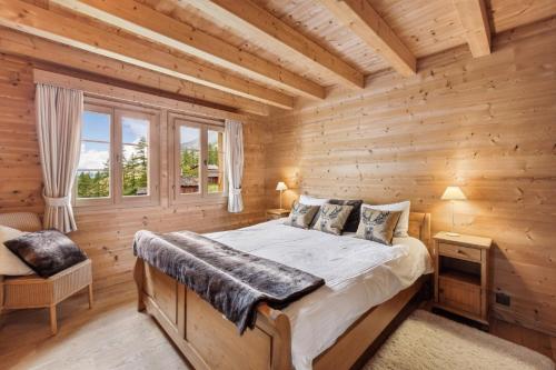 a bedroom with a bed in a log cabin at La Cascade - Appartement Haut Standing La Sage in La Sage