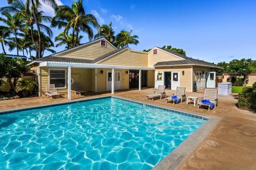 a house with a swimming pool in front of a house at Fairway Terrace F-107 in Waikoloa Village