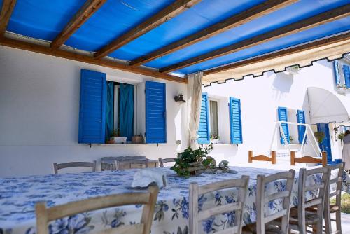 a dining room with blue shutters and a table and chairs at Cà del Mar rustico a Jesolo con giardino e piscina privati ad uso esclusivo # in Jesolo