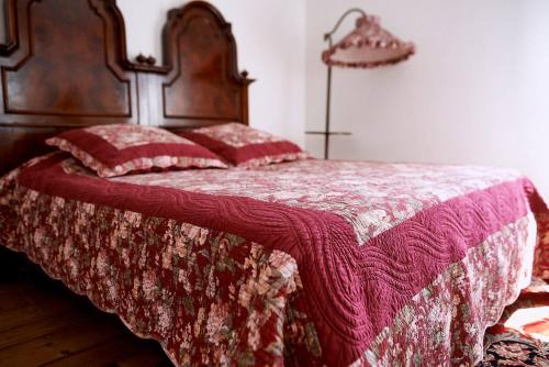 a bed with a red blanket and pillows on it at Cà del Mar rustico a Jesolo con giardino e piscina privati ad uso esclusivo # in Jesolo