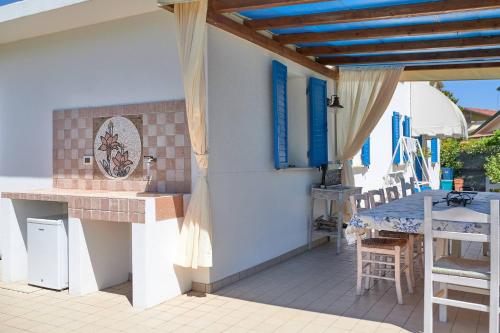 a patio with a table and a table and chairs at Cà del Mar rustico a Jesolo con giardino e piscina privati ad uso esclusivo # in Jesolo