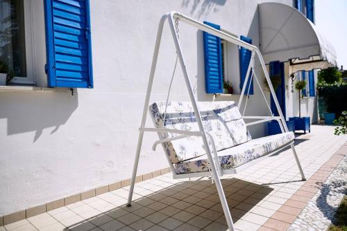 a white porch swing sitting outside of a house at Cà del Mar rustico a Jesolo con giardino e piscina privati ad uso esclusivo # in Jesolo