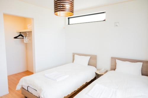 two beds sitting next to each other in a room at IBUNOYA Yaese in Yaese
