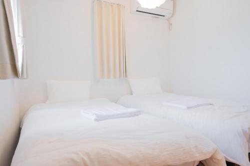 a bedroom with a white bed and a mirror at IBUNOYA Yaese in Yaese