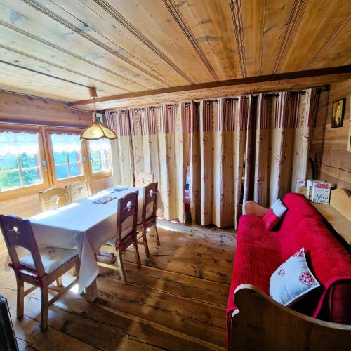 a dining room with a table and a couch at Mayen Motau - Retour a l essentiel La Forclaz in La Forclaz