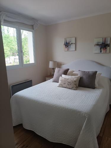 a white bed in a white bedroom with a window at Le Charme des Bastides in Castelnau-de-Montmiral