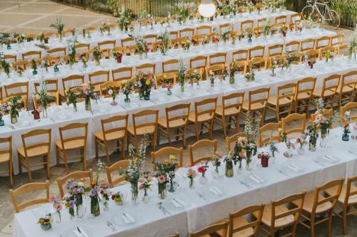 a table set up for a wedding with flowers in vases at Leano Agriresort in Piazza Armerina
