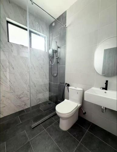 a bathroom with a toilet and a shower and a sink at Warm & Cozy Home in Kampong Duson Gilap