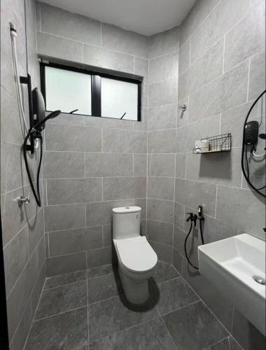 a bathroom with a toilet and a sink at Warm & Cozy Home in Kampong Duson Gilap