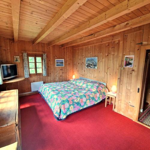 a bedroom with a bed in a wooden room at Tourbillon Gerber - Chalet authentique La Sage in La Sage