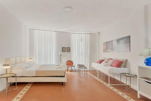 a white bedroom with a bed and a couch at Vernazza Prestige 5TERRE 30 mt the sea AC in Vernazza