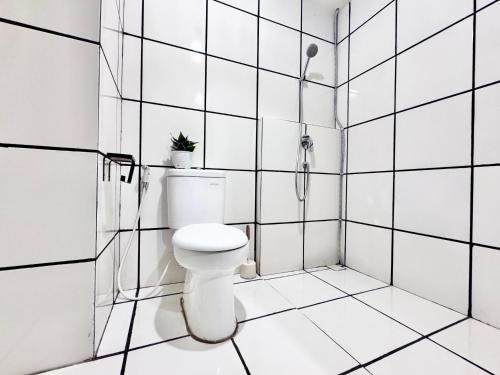 a white bathroom with a toilet and a shower at Cozy 2BR Apartment in City Square East Surabaya by Le Ciel Hospitality in Surabaya