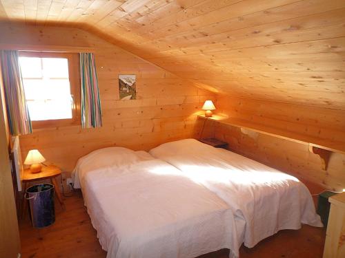 a bedroom with two beds in a log cabin at Chalet Le Recoulet 4 personnes - Evolene in Evolène