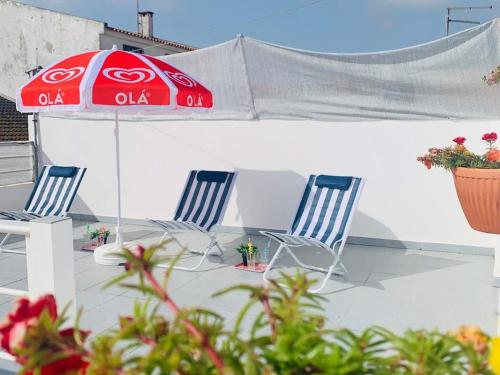 two chairs and an umbrella on a patio at Refugio Terrace House Peniche in Atouguia da Baleia