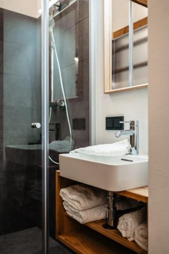 a bathroom with a sink and a shower at Brandlalm Chalets in Gundisch