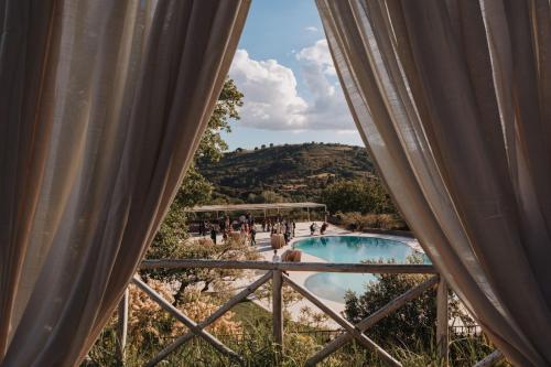 a view of a swimming pool from a window at Leano Agriresort in Piazza Armerina