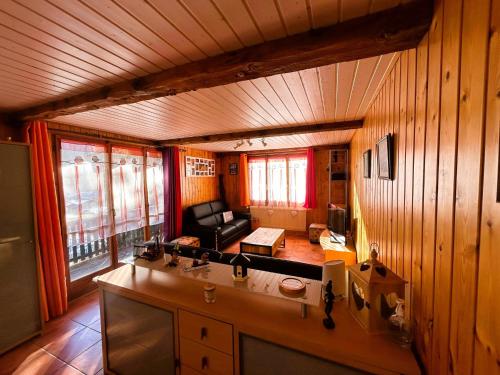 a kitchen with wooden walls and a couch in a room at Beau Sejour 2 - Appartement 6 personnes - Evolene in Evolène