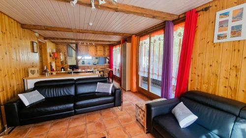 a living room with two leather couches and a kitchen at Beau Sejour 2 - Appartement 6 personnes - Evolene in Evolène