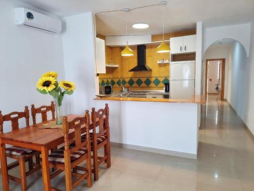 a kitchen and dining room with a wooden table and chairs at Apartamentos Catalina C in Turre