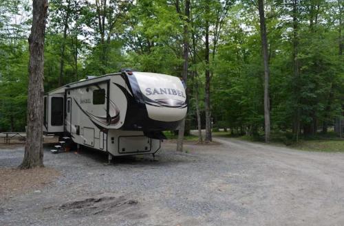 a santa cruz trailer parked in the woods at Water and Electric 30 Amp Pull through up to 24 Site ONLY in Gaines