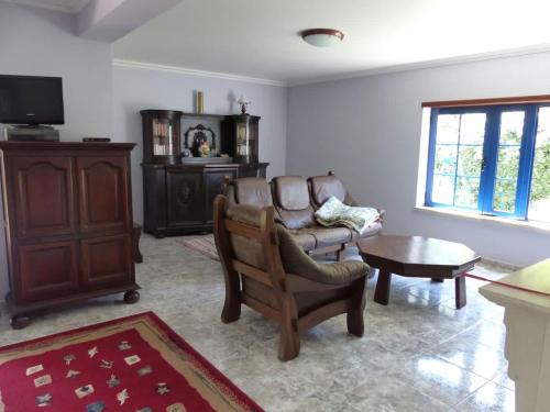 a living room with a chair and a table at Casa Cecilia Seaside Serenity and Coastal Charm in Coimbrão