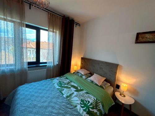 a bedroom with a bed and a large window at Holiday Home ESKU in Orşova