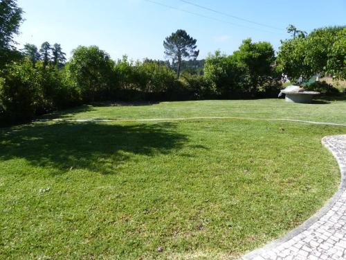 a large grassy yard with a stone walkway at Casa Cecilia Seaside Serenity and Coastal Charm in Coimbrão