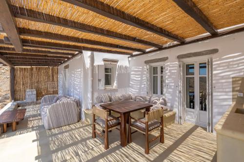 a patio with a wooden table and chairs at Petradi Studios & Villa in Aegiali