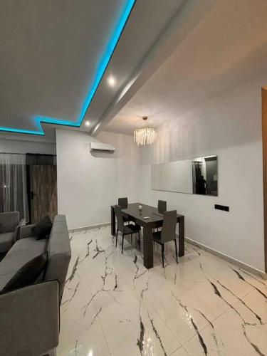 a dining room with a table and a couch at Appartement moderne in Marrakech