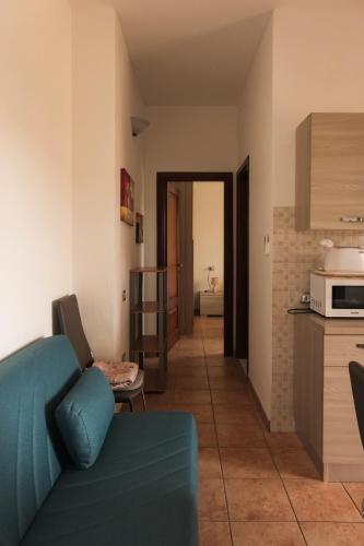 a living room with a blue couch and a kitchen at Casa Cristallina in Posada