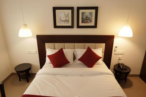 une chambre avec un lit avec des oreillers rouges et blancs dans l'établissement Arabian Pearl Beach Resort Cherai, à Cochin