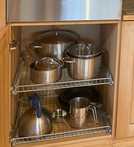 a bunch of pots and pans in a cabinet at Villa Verde by Hvalstrand beach in Nesbru