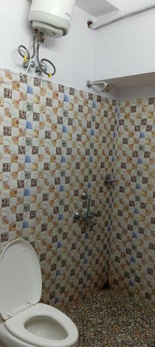 a bathroom with a toilet and a shower at Sacred Stay in Guwahati