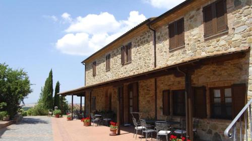 a building with tables and chairs outside of it at Agriturismo Casale trieste in Laiatico