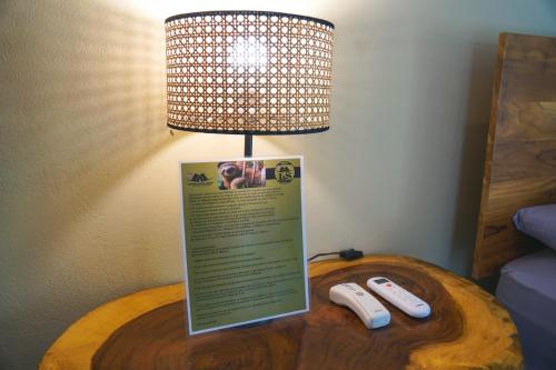 a table with a lamp and two remote controls on it at Bamboo River Lodge in Horquetas